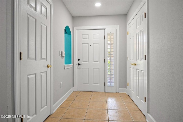 215 S Ocean Grande Dr Unit 105, Ponte Vedra Beach, FL 32082 - foyer featuring baseboards, light tile patterned flooring, and arched walkways