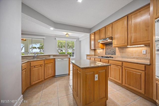 215 S Ocean Grande Dr Unit 105, Ponte Vedra Beach, FL 32082 - kitchen featuring dishwasher, a sink, under cabinet range hood, gas cooktop, and a textured ceiling