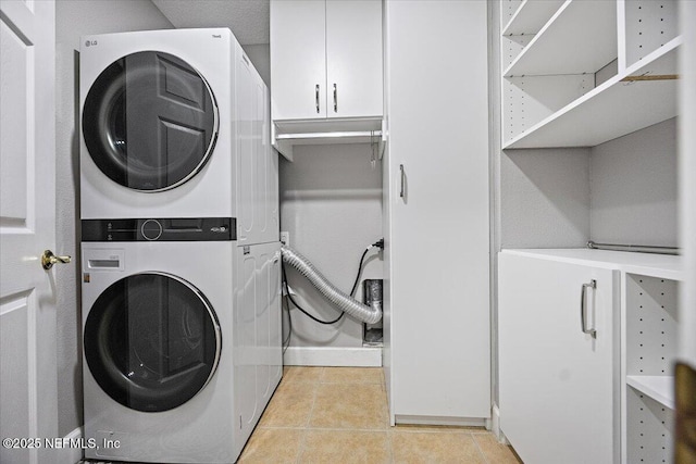 215 S Ocean Grande Dr Unit 105, Ponte Vedra Beach, FL 32082 - washroom with stacked washer / dryer, light tile patterned floors, baseboards, and cabinet space