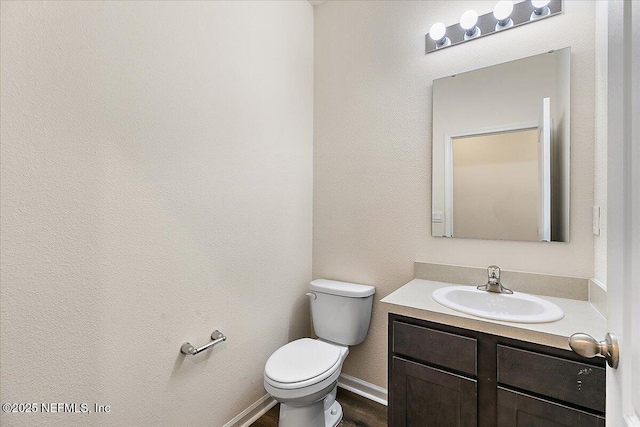 187 Logrono Ct, Saint Augustine, FL 32084 - half bath featuring vanity, toilet, wood finished floors, and baseboards