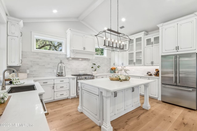 22 N 17th St, Amelia Island, FL 32034 - kitchen featuring stainless steel appliances, a sink, white cabinets, tasteful backsplash, and light countertops