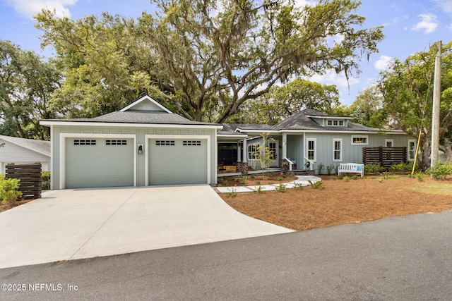 22 N 17th St, Amelia Island, FL 32034 - view of front of house with board and batten siding, concrete driveway, roof with shingles, and an attached garage