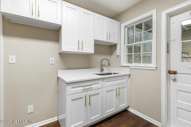 937 Stark St, Jacksonville, FL 32208 - kitchen featuring a sink, white cabinetry, dark wood-style flooring, light countertops, and baseboards