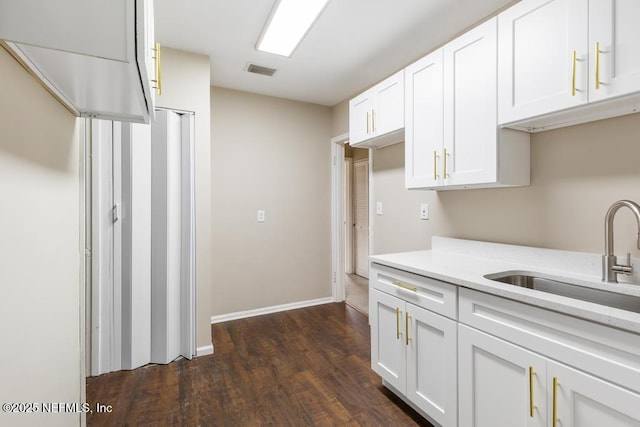 937 Stark St, Jacksonville, FL 32208 - kitchen with a sink, light countertops, dark wood finished floors, and white cabinets