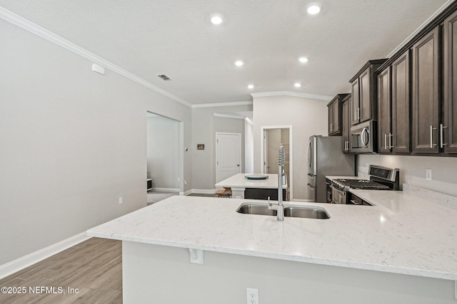 285 Greenway Ln, Saint Augustine, FL 32092 - kitchen with stainless steel appliances, a sink, crown molding, recessed lighting, and light wood-style flooring