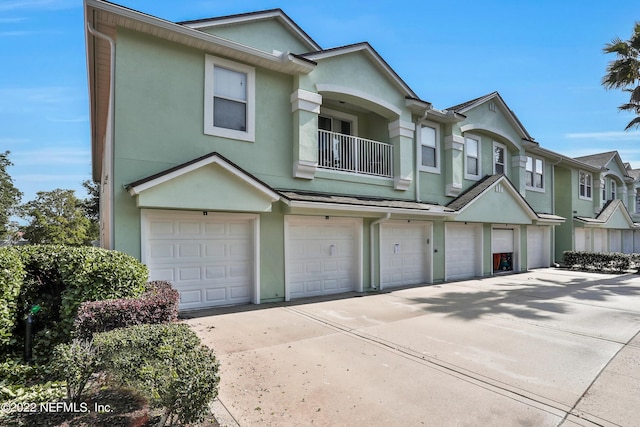 13793 Herons Landing Way Unit 4, Jacksonville, FL 32224 - view of property featuring stucco siding, driveway, an attached garage, and a balcony