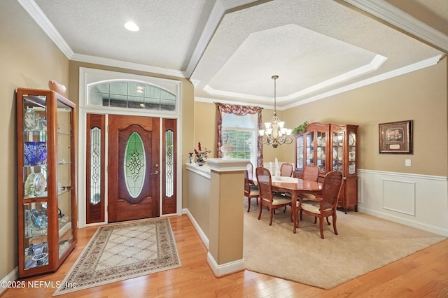 501 Greenbriar Rd, Saint Johns, FL 32259 - entrance foyer featuring a textured ceiling, a chandelier, light wood-style flooring, ornamental molding, and a wainscoted wall