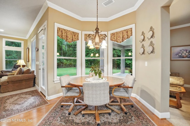 501 Greenbriar Rd, Saint Johns, FL 32259 - dining area featuring light wood finished floors, a chandelier, baseboards, and crown molding