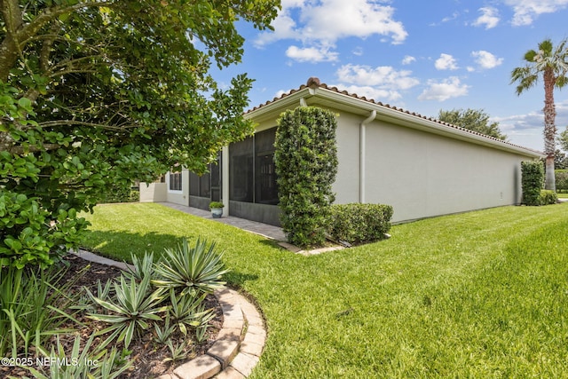14 Marsh Hollow Rd, Ponte Vedra, FL 32081 - view of property exterior with a sunroom, a yard, stucco siding, and a tile roof