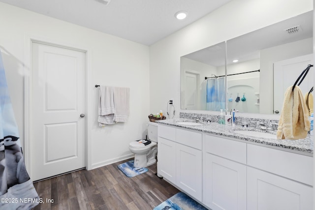 724 Liberty Cir, Macclenny, FL 32063 - full bath with toilet, double vanity, wood finished floors, a shower with curtain, and baseboards