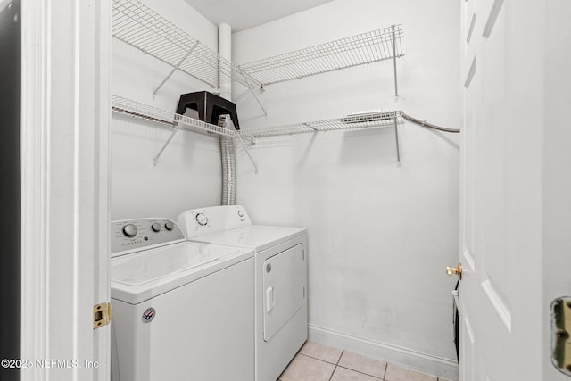 225 Presidents Cup Way Unit 105, Saint Augustine, FL 32092 - laundry area featuring washing machine and clothes dryer, light tile patterned flooring, and baseboards
