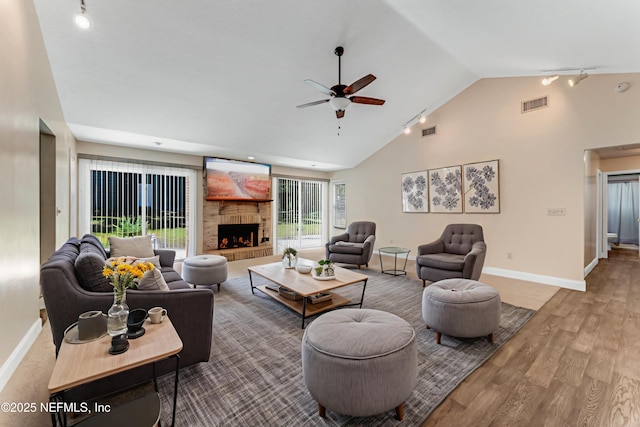 2270 Wilmhurst Rd, Deland, FL 32720 - living room with rail lighting, a ceiling fan, wood finished floors, a fireplace with raised hearth, and high vaulted ceiling