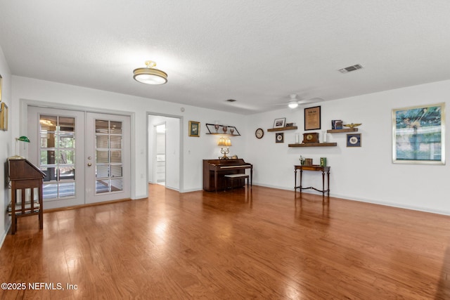 13674 Wm Davis Pkwy, Jacksonville, FL 32224 - living room featuring french doors, wood finished floors, ceiling fan, baseboards, and a textured ceiling