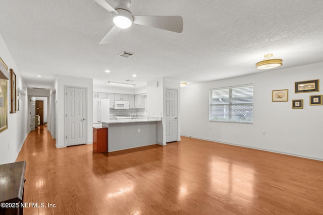 13674 Wm Davis Pkwy, Jacksonville, FL 32224 - unfurnished living room featuring light wood finished floors, a ceiling fan, a textured ceiling, recessed lighting, and baseboards