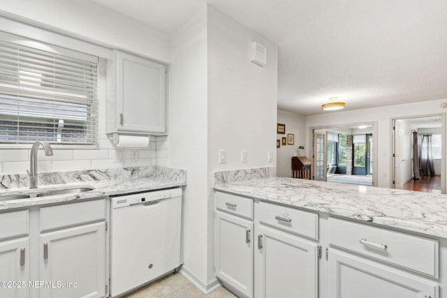 13674 Wm Davis Pkwy, Jacksonville, FL 32224 - kitchen with dishwasher, a sink, white cabinets, light tile patterned flooring, and light stone counters