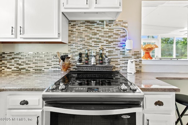 1810 Griflet Rd, Jacksonville, FL 32211 - kitchen featuring range with electric stovetop, white cabinetry, backsplash, and light stone counters