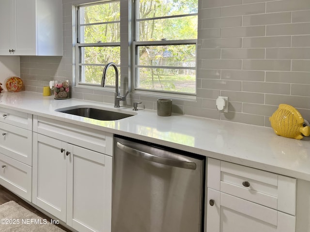 5256 Alpha Ave, Jacksonville, FL 32205 - kitchen with stainless steel dishwasher, a sink, tasteful backsplash, and white cabinetry