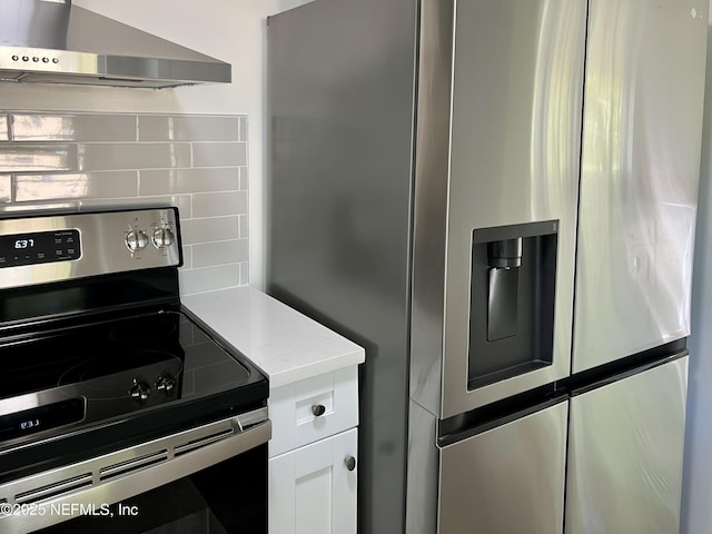 5256 Alpha Ave, Jacksonville, FL 32205 - kitchen with appliances with stainless steel finishes, wall chimney exhaust hood, decorative backsplash, white cabinetry, and light stone counters