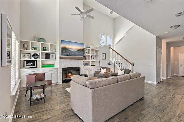 436 Marsh Cove Dr, Ponte Vedra Beach, FL 32082 - living area featuring a high ceiling, a glass covered fireplace, dark wood-style flooring, a ceiling fan, and stairs
