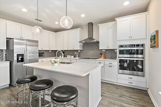 436 Marsh Cove Dr, Ponte Vedra Beach, FL 32082 - kitchen featuring wall chimney range hood, appliances with stainless steel finishes, dark wood finished floors, tasteful backsplash, and recessed lighting