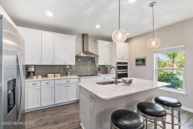 436 Marsh Cove Dr, Ponte Vedra Beach, FL 32082 - kitchen featuring wall chimney range hood, appliances with stainless steel finishes, dark wood-style flooring, tasteful backsplash, and white cabinetry