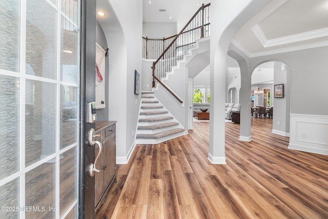 143 Istoria Dr, Saint Augustine, FL 32095 - entryway with light wood-style floors, crown molding, arched walkways, stairway, and baseboards