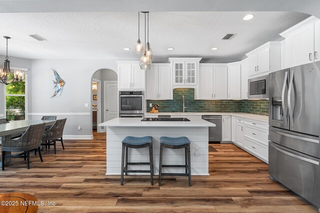 143 Istoria Dr, Saint Augustine, FL 32095 - kitchen with stainless steel appliances, arched walkways, light countertops, tasteful backsplash, and a textured ceiling