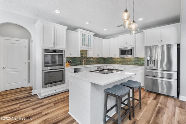 143 Istoria Dr, Saint Augustine, FL 32095 - kitchen featuring appliances with stainless steel finishes, wood finished floors, a sink, white cabinetry, and recessed lighting