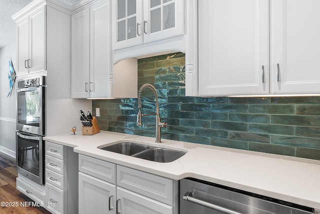 143 Istoria Dr, Saint Augustine, FL 32095 - kitchen with appliances with stainless steel finishes, a sink, white cabinets, glass insert cabinets, and decorative backsplash