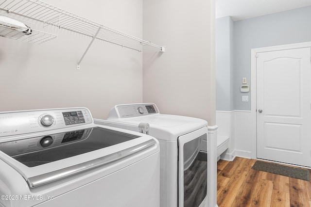 143 Istoria Dr, Saint Augustine, FL 32095 - laundry area featuring washer and clothes dryer, wood finished floors, and a wainscoted wall