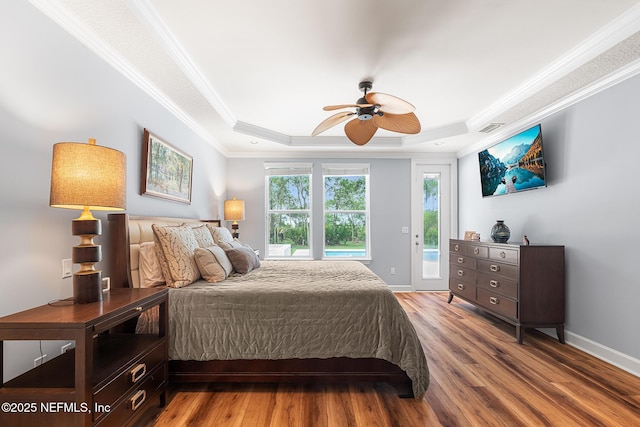 143 Istoria Dr, Saint Augustine, FL 32095 - bedroom featuring access to exterior, a raised ceiling, crown molding, wood finished floors, and baseboards