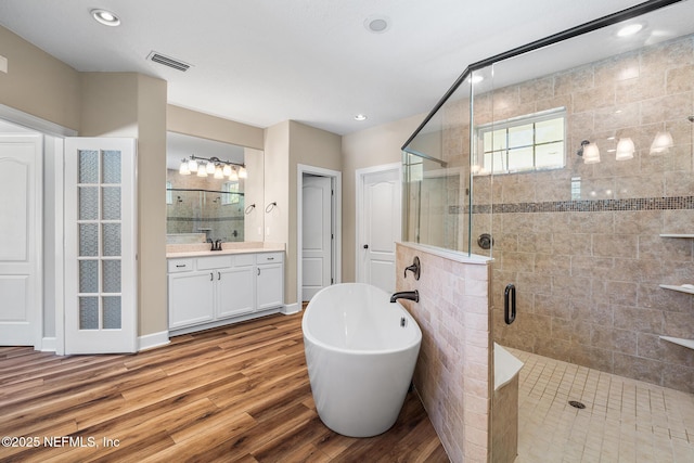 143 Istoria Dr, Saint Augustine, FL 32095 - full bath with a stall shower, a soaking tub, wood finished floors, vanity, and recessed lighting