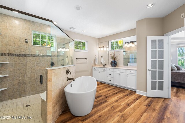 143 Istoria Dr, Saint Augustine, FL 32095 - ensuite bathroom featuring double vanity, wood finished floors, a freestanding bath, a shower stall, and recessed lighting