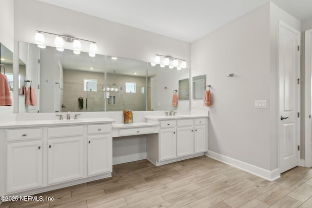 94001 Goodwood Dr, Fernandina Beach, FL 32034 - bathroom featuring two vanities, tiled shower, wood finished floors, and baseboards