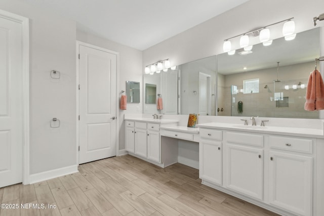 94001 Goodwood Dr, Fernandina Beach, FL 32034 - bathroom featuring double vanity, a tile shower, wood finished floors, and baseboards