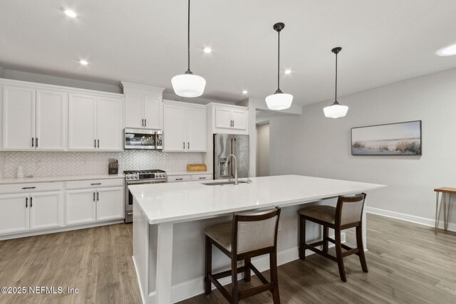 94001 Goodwood Dr, Fernandina Beach, FL 32034 - kitchen featuring appliances with stainless steel finishes, a sink, light wood finished floors, backsplash, and recessed lighting