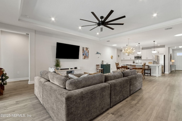 94001 Goodwood Dr, Fernandina Beach, FL 32034 - living room with crown molding, light wood-style floors, a ceiling fan, a chandelier, and baseboards