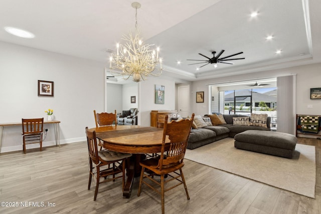 94001 Goodwood Dr, Fernandina Beach, FL 32034 - dining room featuring light wood finished floors, a raised ceiling, a chandelier, a ceiling fan, and recessed lighting