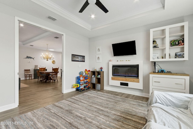 94001 Goodwood Dr, Fernandina Beach, FL 32034 - living room with ornamental molding, wood finished floors, ceiling fan, a glass covered fireplace, and a chandelier