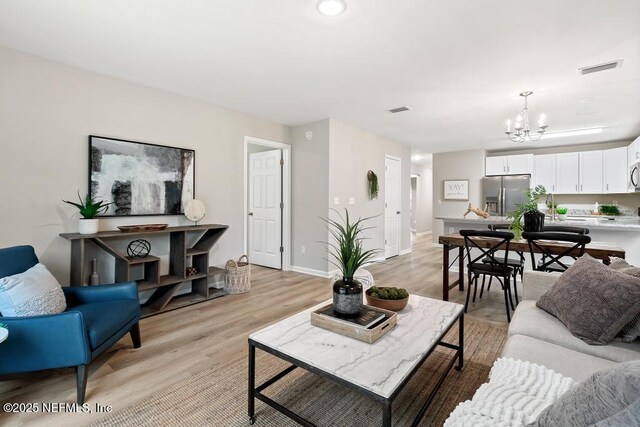 889 Aiken St, Saint Augustine, FL 32084 - living area with a chandelier, light wood-style floors, and baseboards