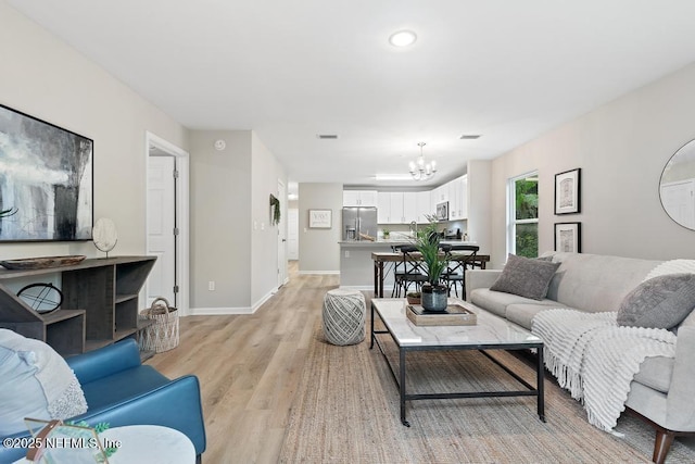 889 Aiken St, Saint Augustine, FL 32084 - living room with a chandelier, light wood-type flooring, and baseboards