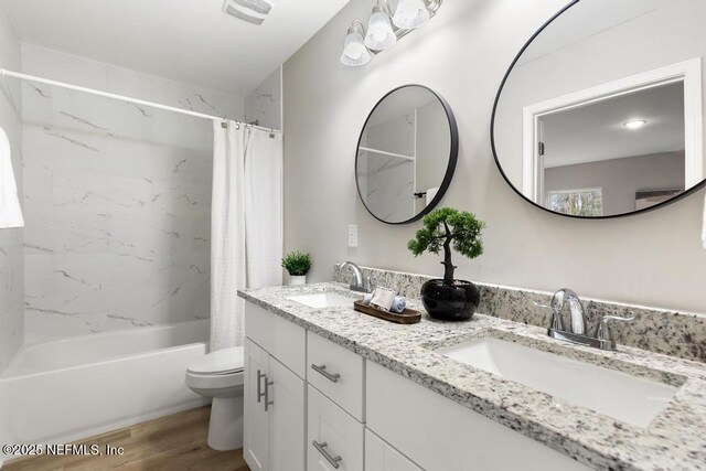 889 Aiken St, Saint Augustine, FL 32084 - bathroom featuring double vanity, shower / bathtub combination with curtain, wood finished floors, and toilet