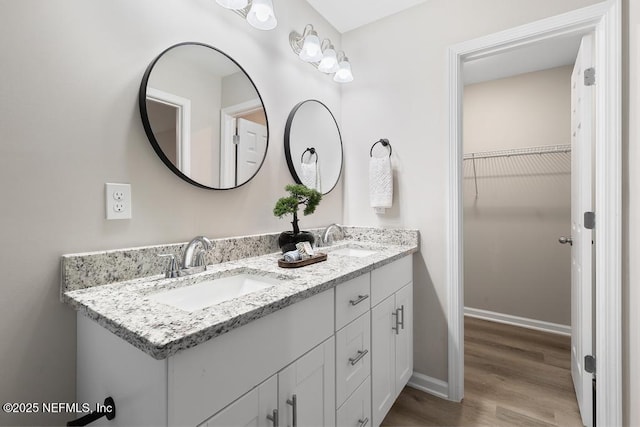 889 Aiken St, Saint Augustine, FL 32084 - full bathroom with double vanity, wood finished floors, baseboards, and a walk in closet