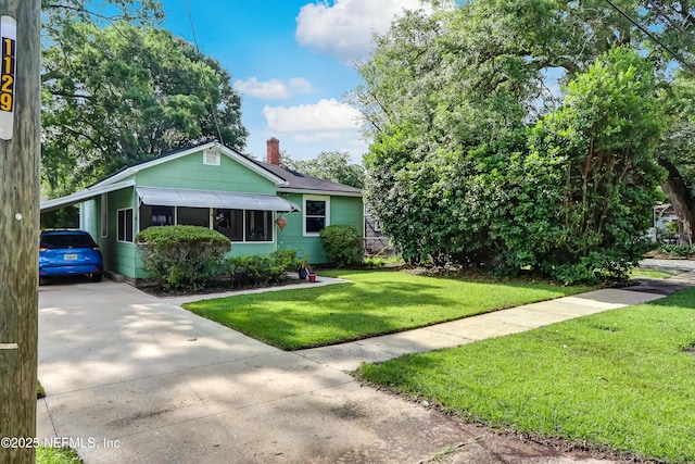 1131 Wycoff Ave, Jacksonville, FL 32205 - view of front of house featuring driveway, a chimney, and a front lawn