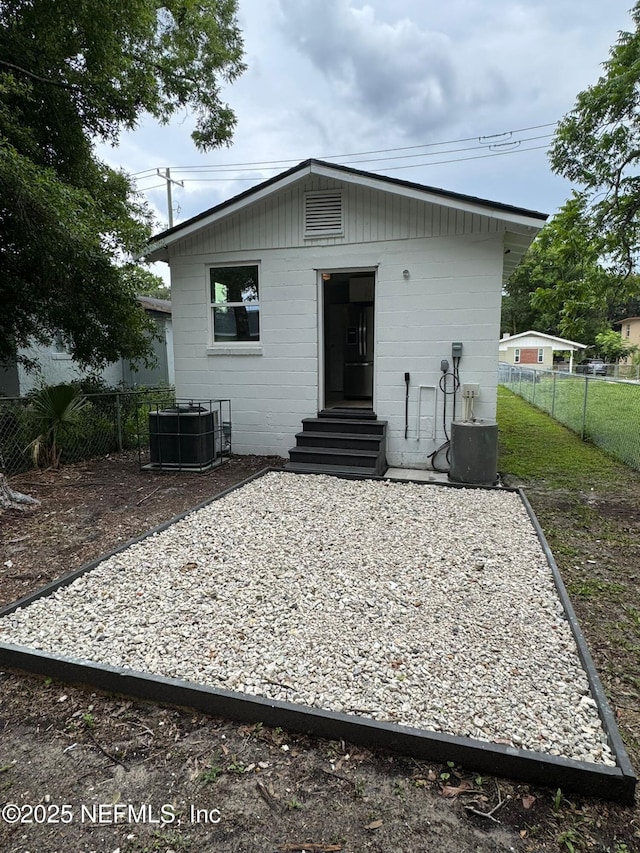 1413 W 21st St, Jacksonville, FL 32209 - rear view of property with entry steps, cooling unit, a fenced backyard, and concrete block siding