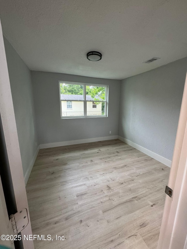 1413 W 21st St, Jacksonville, FL 32209 - spare room with light wood-type flooring, a textured ceiling, and baseboards