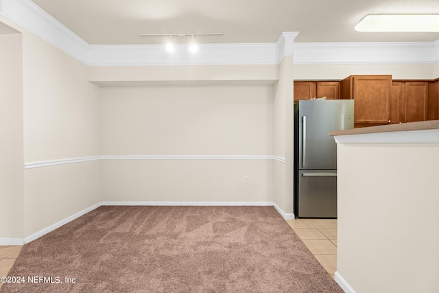 8550 Touchton Rd Unit 122, Jacksonville, FL 32216 - kitchen featuring freestanding refrigerator, light tile patterned floors, brown cabinets, light carpet, and crown molding