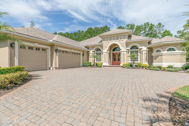 2435 Den St, Saint Augustine, FL 32092 - mediterranean / spanish-style home with french doors, stucco siding, an attached garage, and decorative driveway