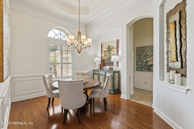 2435 Den St, Saint Augustine, FL 32092 - dining room with arched walkways, wood finished floors, ornamental molding, a tray ceiling, and a chandelier