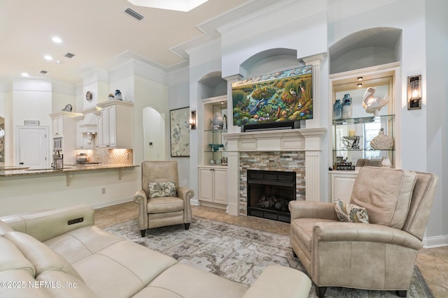 2435 Den St, Saint Augustine, FL 32092 - living area with a stone fireplace, crown molding, arched walkways, and recessed lighting